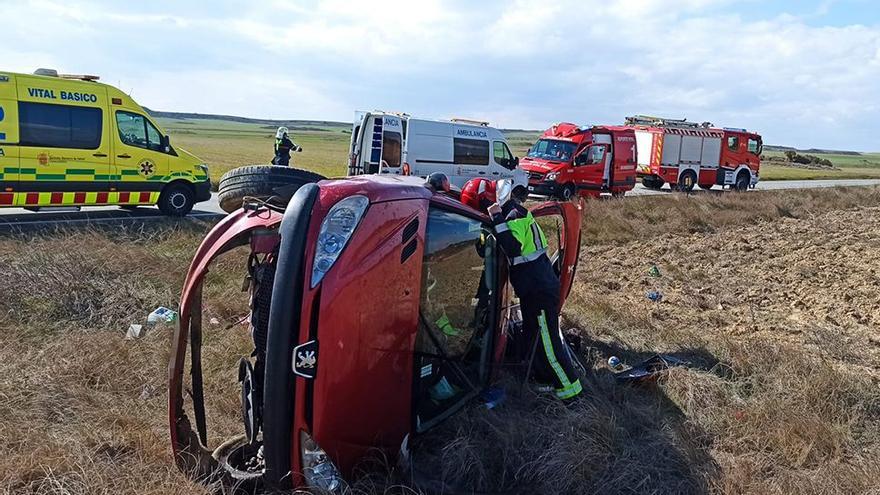 Un bombero examina el coche accidentado.