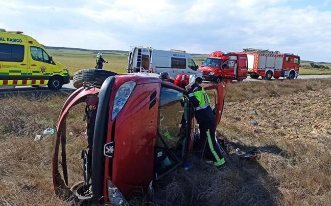 Un bombero examina el coche accidentado.