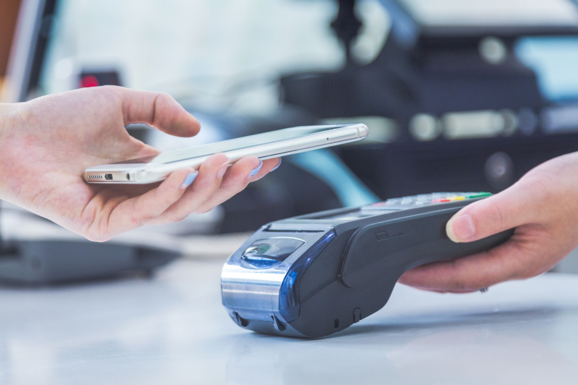 Una consumidora realiza un pago con el móvil.