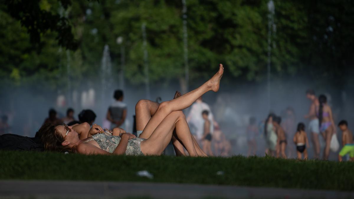 Varias personas se refrescan en las fuentes de Madrid Río.