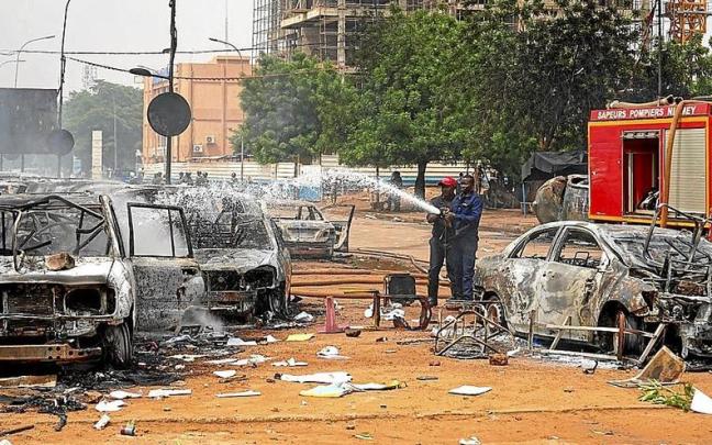 Bomberos tratan de sofocar el incendio en varios coches calcinados en las protestas por el golpe. | FOTO: EFE Bomberos tratan de sofocar el incendio en varios coches calcinados en las protestas por el golpe. | FOTO: EFE