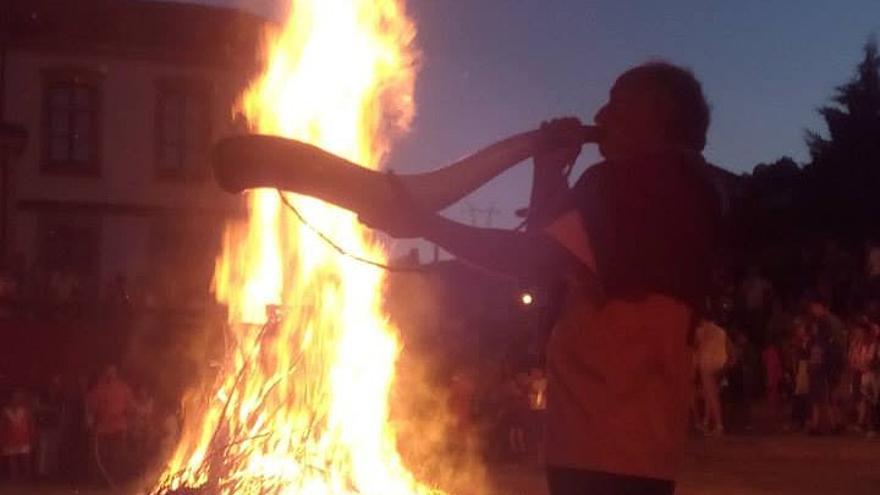 El maestro artesano Alaña toca el cuerno con la hoguera del soslticio de verano de fondo en Artziniega