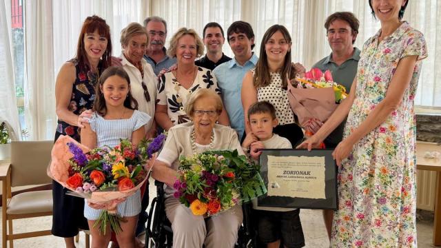 Abdona sonriente en el centro, arropada por familiares y la concejala Maite Usabiaga en el día en el que sopla las velas de su 100 cumpleaños.