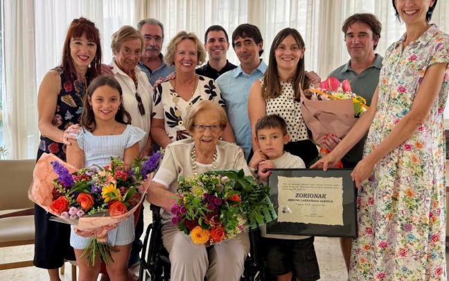 Abdona sonriente en el centro, arropada por familiares y la concejala Maite Usabiaga en el día en el que sopla las velas de su 100 cumpleaños.