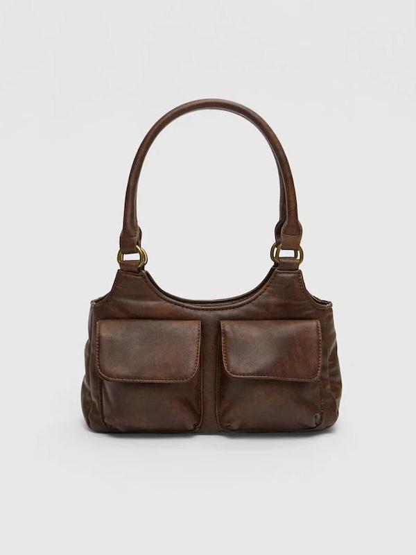 Pequeño bolso efecto piel lleno de detalles.