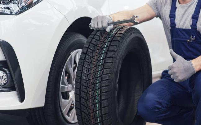 Un mecánico se dispone a cambiar un neumático.