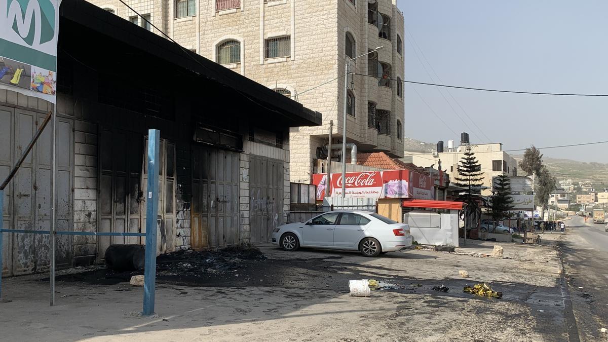 Vista de negocios, coches y edificios palestinos calcinados en Huwara.