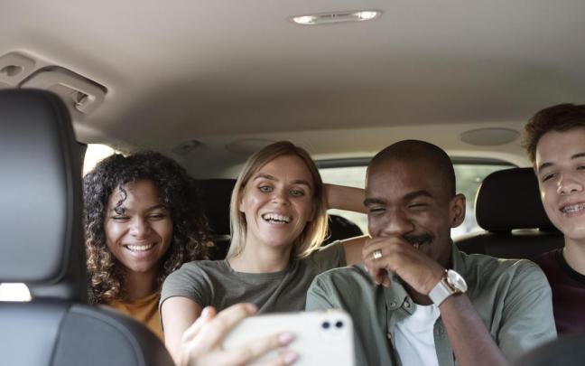 Tres jóvenes parecen divertirse en un coche. / Freepik Tres jóvenes parecen divertirse en un coche.