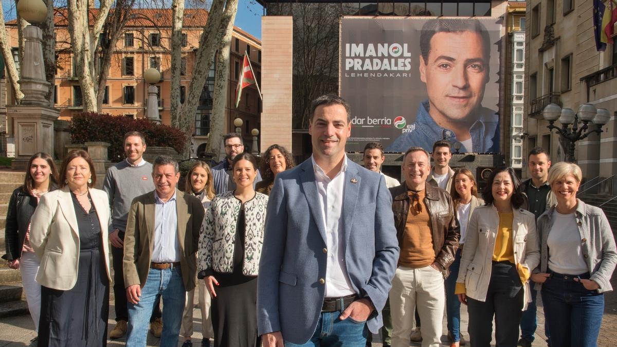 El candidato del PNV a lehendakari, Imanol Pradales, con compañeros de la candidatura por Bizkaia, ante la lona electoral en Sabin Etxea