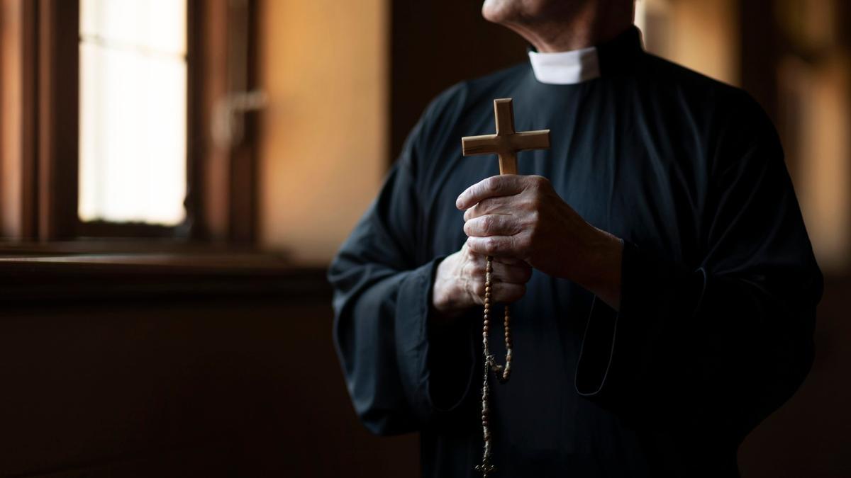 Un sacerdote, con una cruz.