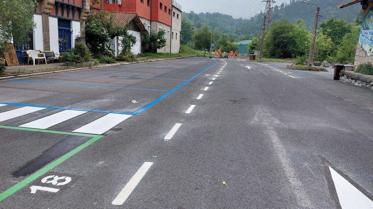 Operarios ultiman el pintado de la zona de estacionamiento de autocaravanas.