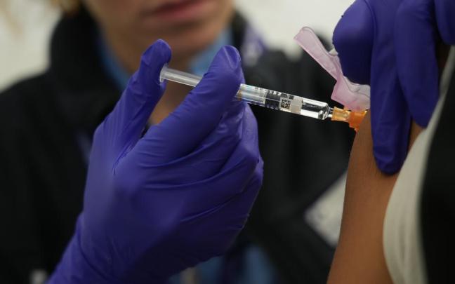 Una persona se vacuna en un centro de refuerzo de vacunación frente a la gripe