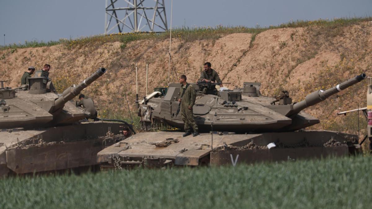 Soldados israelíes sobre tanques en la frontera con la Franja de Gaza.