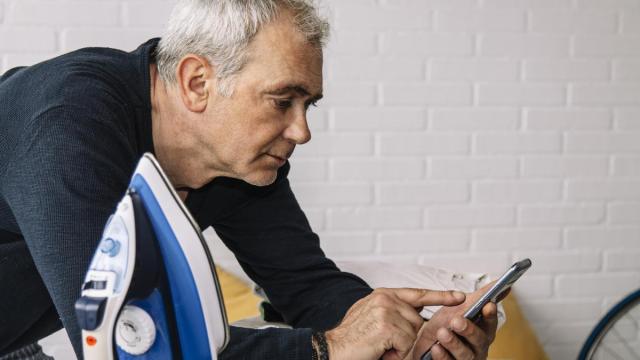 Un señor ajeno a esta historia mira su teléfono móvil con la plancha al lado.