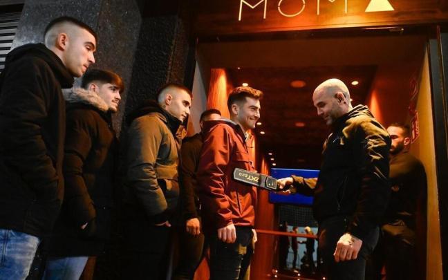 El encargado de acceso a una discoteca utiliza un detector de metales.