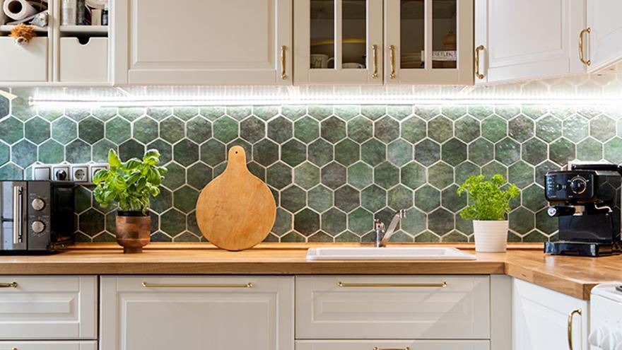 Cocina decorada con azulejos hexagonales verdes.