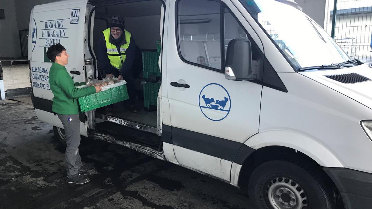 Una trabajadora de Mercadona entrega comida a una furgoneta del Banco de Alimentos de Bizkaia.