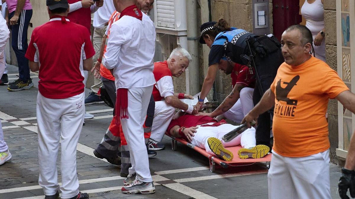 Uno de los corredores heridos es atendido tras el encierro.