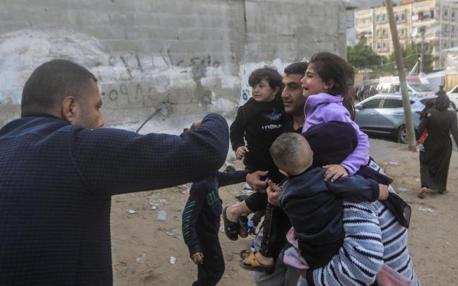 Una familia huye de los bombardeos israelíes sobre Rafah.