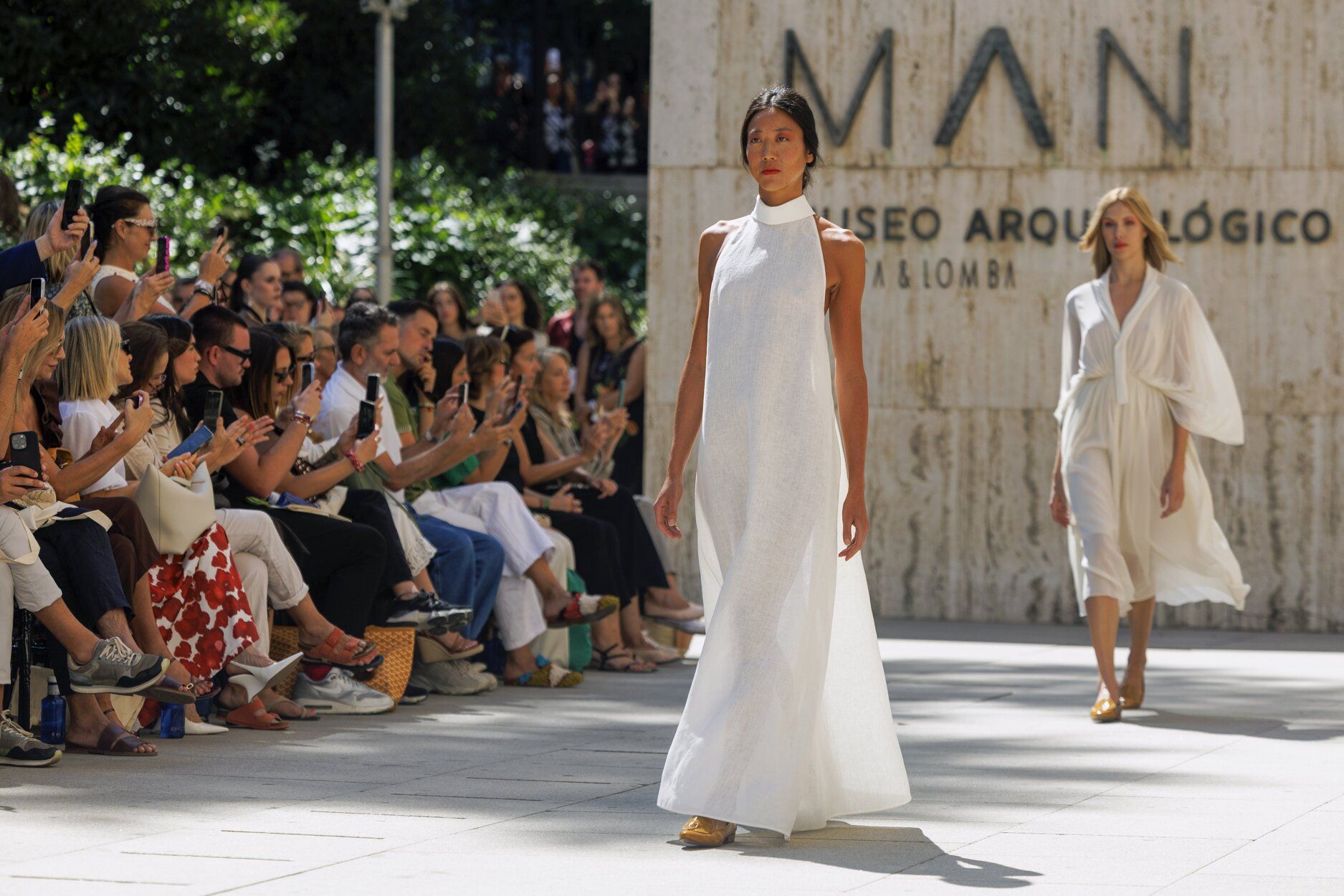 Dos propuestas en blanco. La primera, de cuello halter y líneas rectas, y la segundoa, con pliegues y semitransparencias.