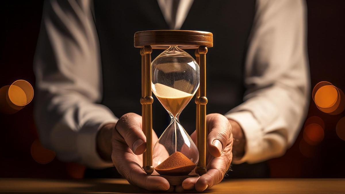 Un hombre de mediana edad sostiene entre sus manos un reloj de arena.