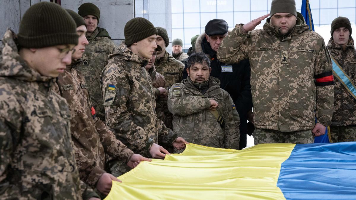 Soldados ucranianos sostienen una bandera durante un homenaje a los caídos en combate. Foto: E.P.