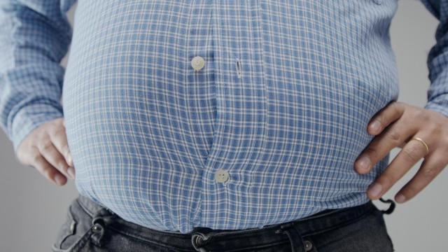 Un hombre luce una prominente barriga. Un hombre luce una prominente barriga.