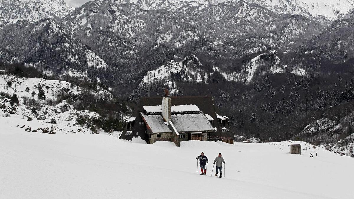 Dos personas caminan con raquetas de nieve en territorio navarro.