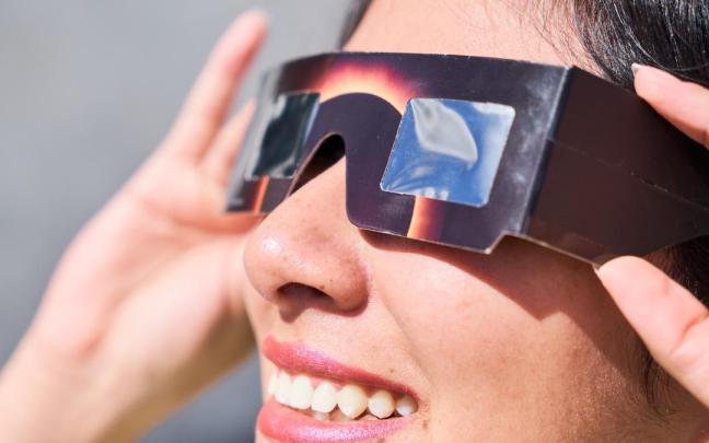 Mujer con gafas solares para eclipse.