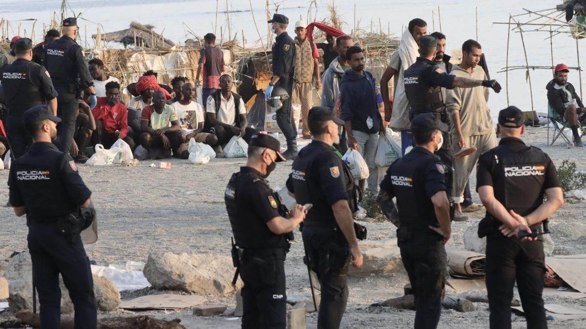 Agentes proceden al traslado de los migrantes que permanecían en la playa del Trampolín.