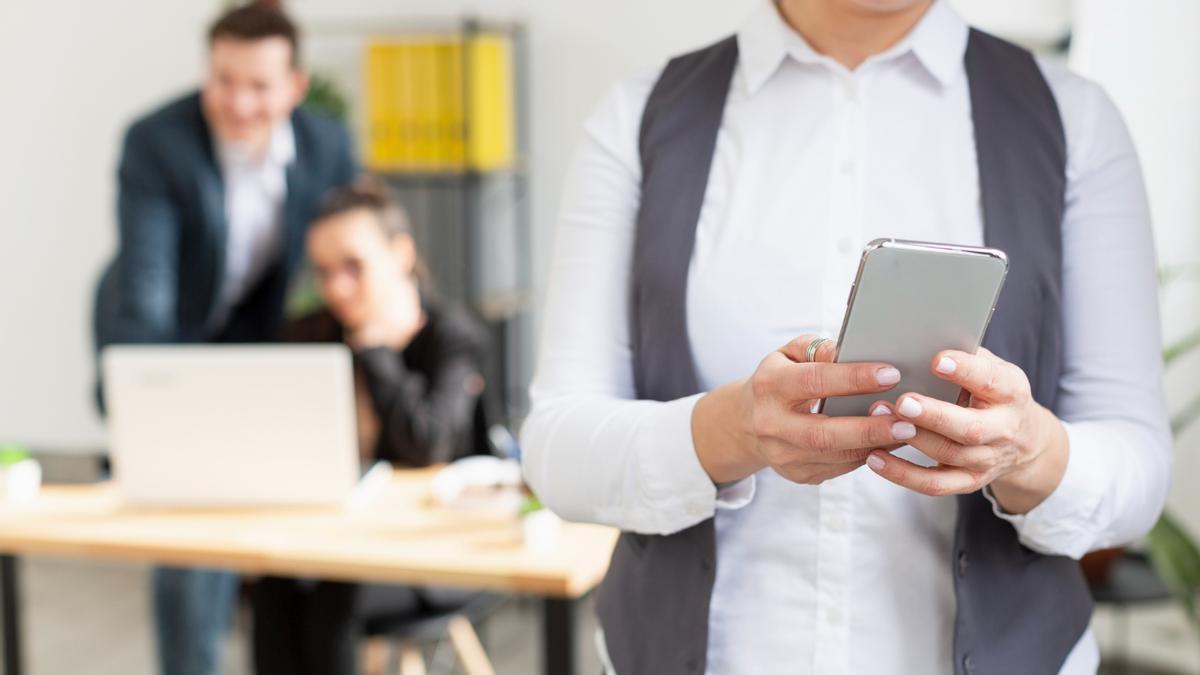 Una persona usa su teléfono móvil durante la jornada laboral