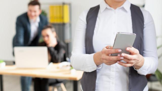 Una persona usa su teléfono móvil durante la jornada laboral