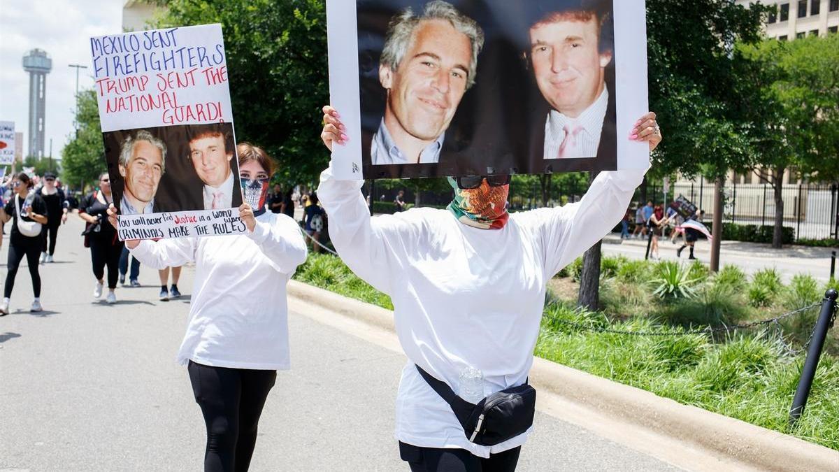 Dos manifestantes en Estados Unidos alzan pancartas que muestran una fotografía de Jeffrey Epstein junto a Donald Trump.