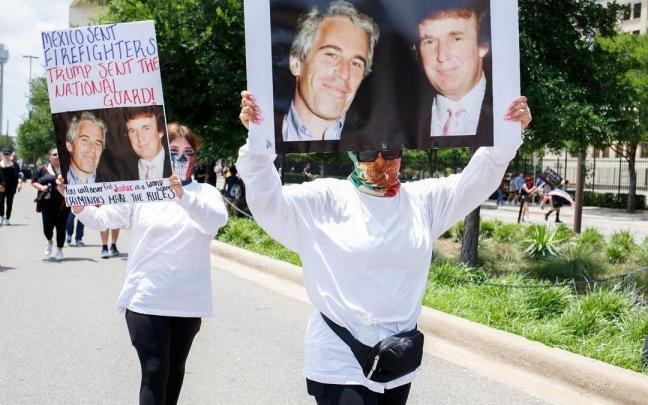 Dos manifestantes en Estados Unidos alzan pancartas que muestran una fotografía de Jeffrey Epstein junto a Donald Trump.