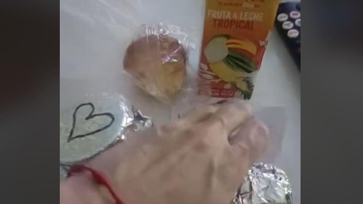 La joven, mostrando la merienda que le entregó un voluntario.