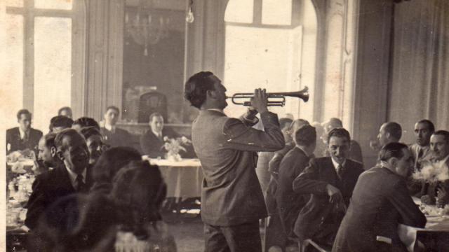 Imagen histórica de Txomin Letamendi tocando la trompeta, con el lehendakari Aguirre y Jesús María Leizaola al fondo.
