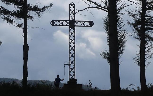 Un joven tocando la campana de la cruz de Beloki.