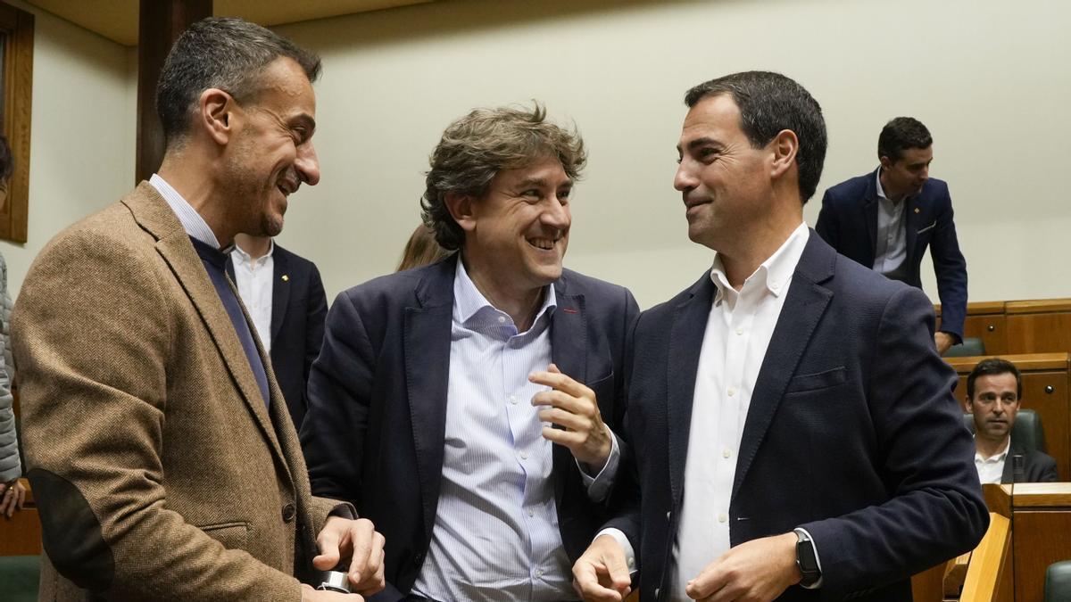 El candidato del PNV a lehendakari, Imanol Pradales, charla con los socialistas Ekain Rico y Eneko Andueza en el Parlamento Vasco.