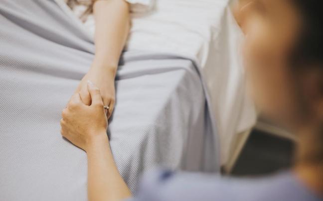 Una persona acompaña a un paciente en un hospital.