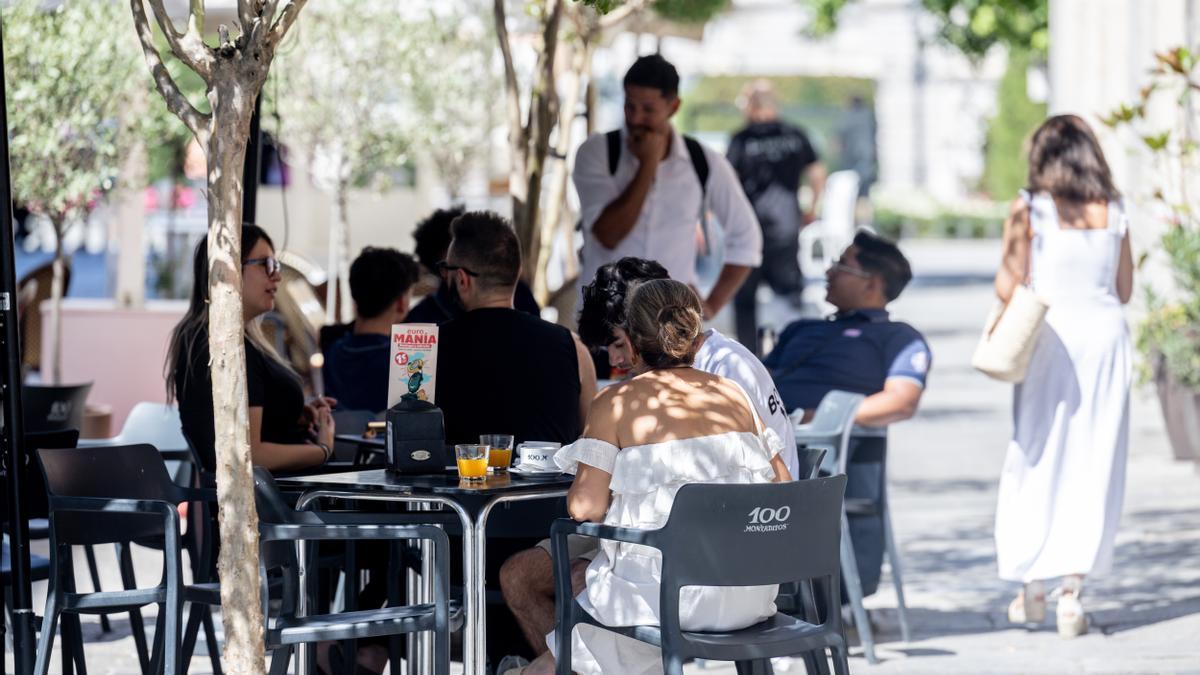 Clientes de un bar se refrescan en la terraza.