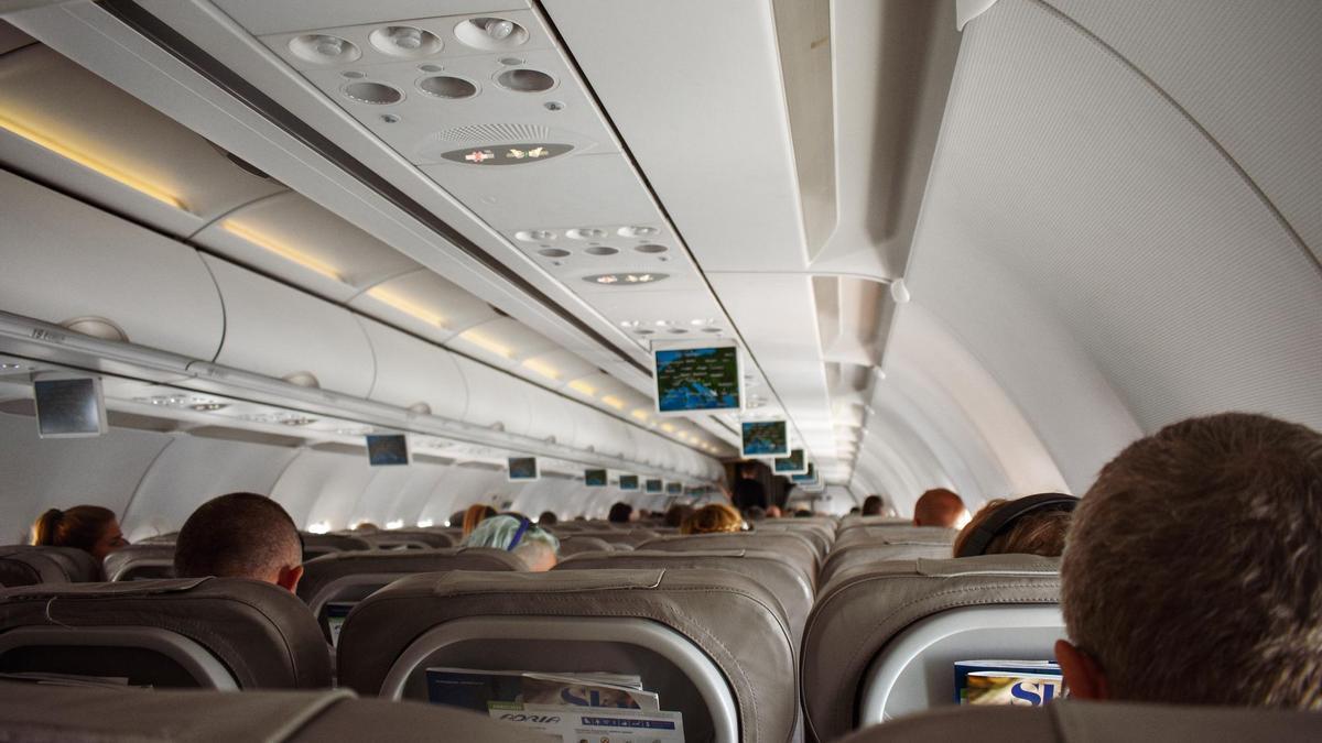 Pasajeros sentados a bordo de un avión.