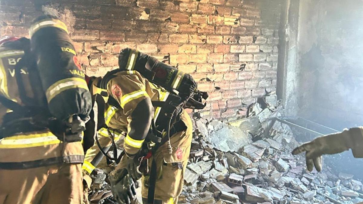 Los bomberos en el edificio incendiado.