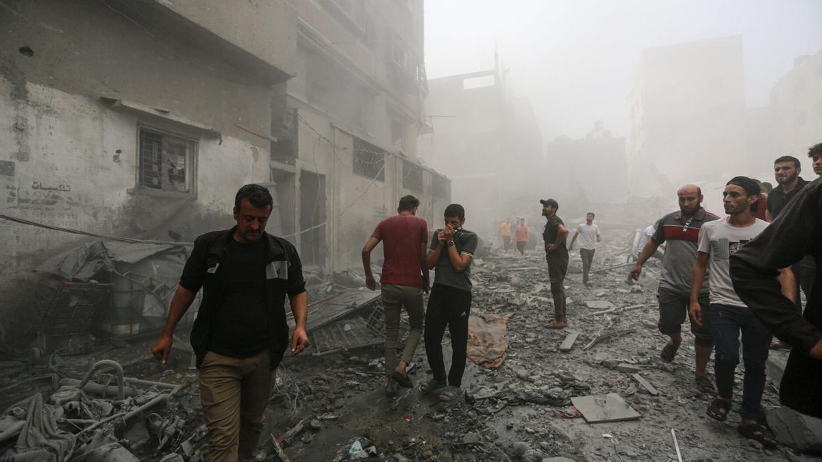 Varias personas comprueban el estado de unos edificios bombardeados en Gaza.