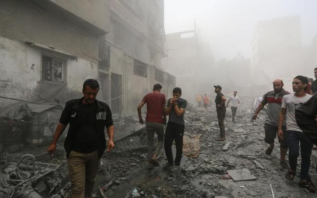 Varias personas comprueban el estado de unos edificios bombardeados en Gaza.