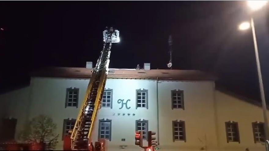 Los bomberos despliegan una escala para desalojar del tejado del antiguo hotel a dos personas, Valladolid.
