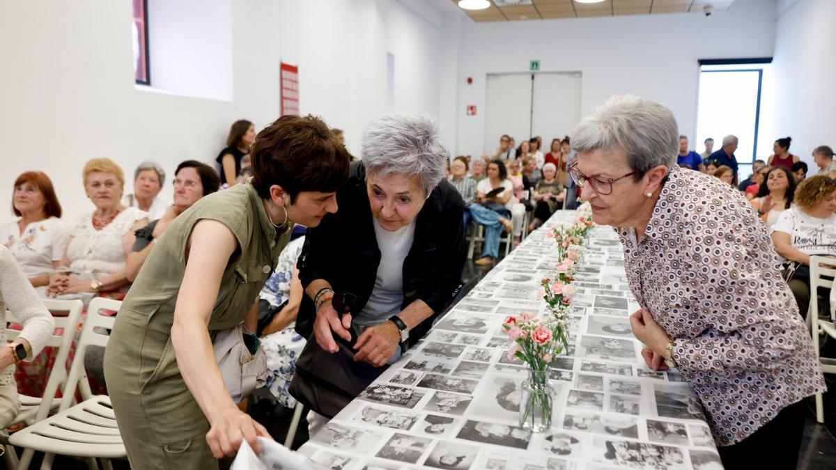 Asistentes a la presentación viendo la gran tela con fotografías