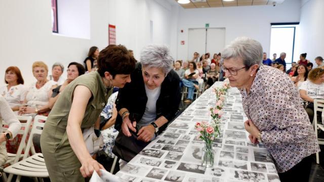Asistentes a la presentación viendo la gran tela con fotografías