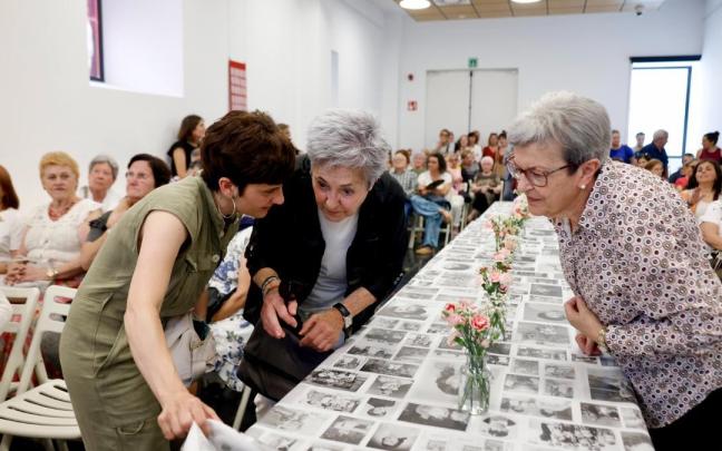 Asistentes a la presentación viendo la gran tela con fotografías