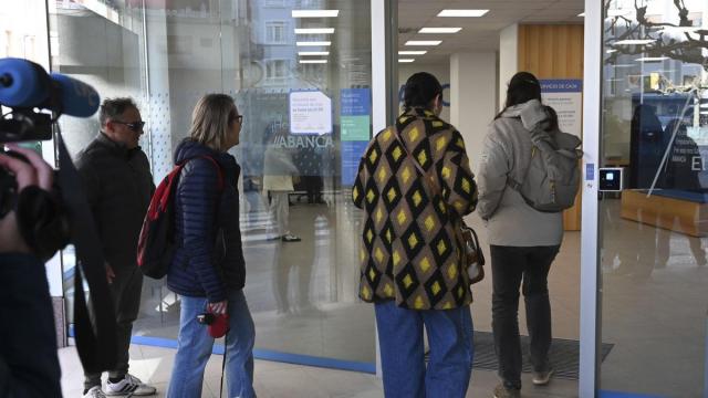 Los vecinos de Villamanín agraciados con el Gordo de Navidad acuden al banco a recoger su parte del premio.