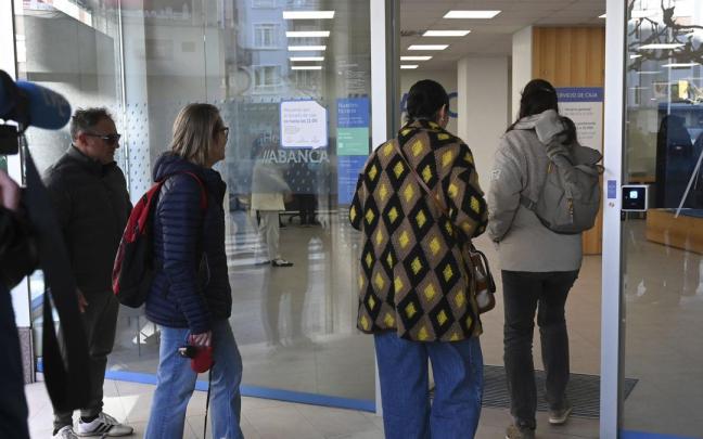 Los vecinos de Villamanín agraciados con el Gordo de Navidad acuden al banco a recoger su parte del premio.